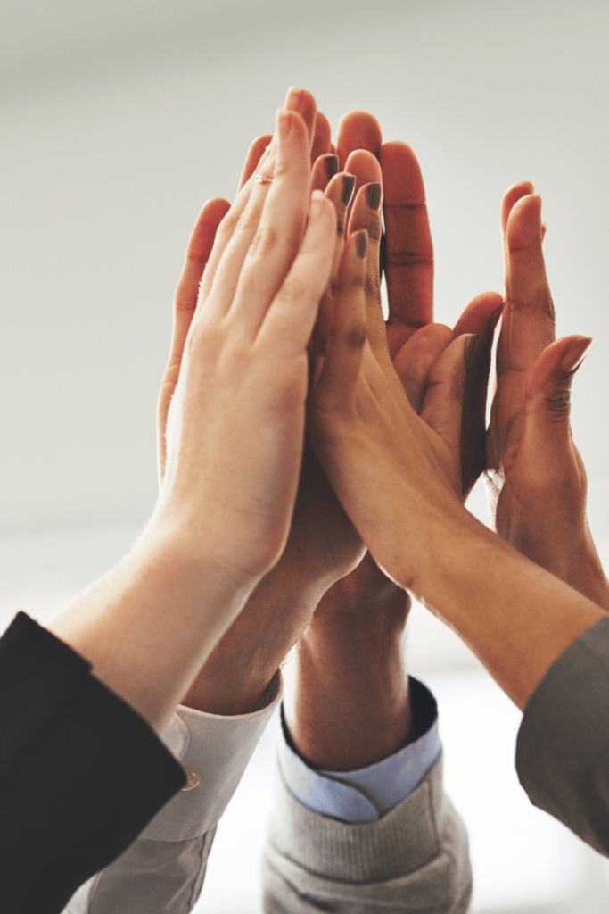 Hands in the air in a high five for business success